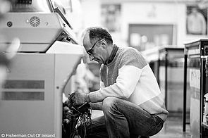 Ein Mitarbeiter von Fisherman out of Ireland prüft die Arbeit der Strickmaschine.