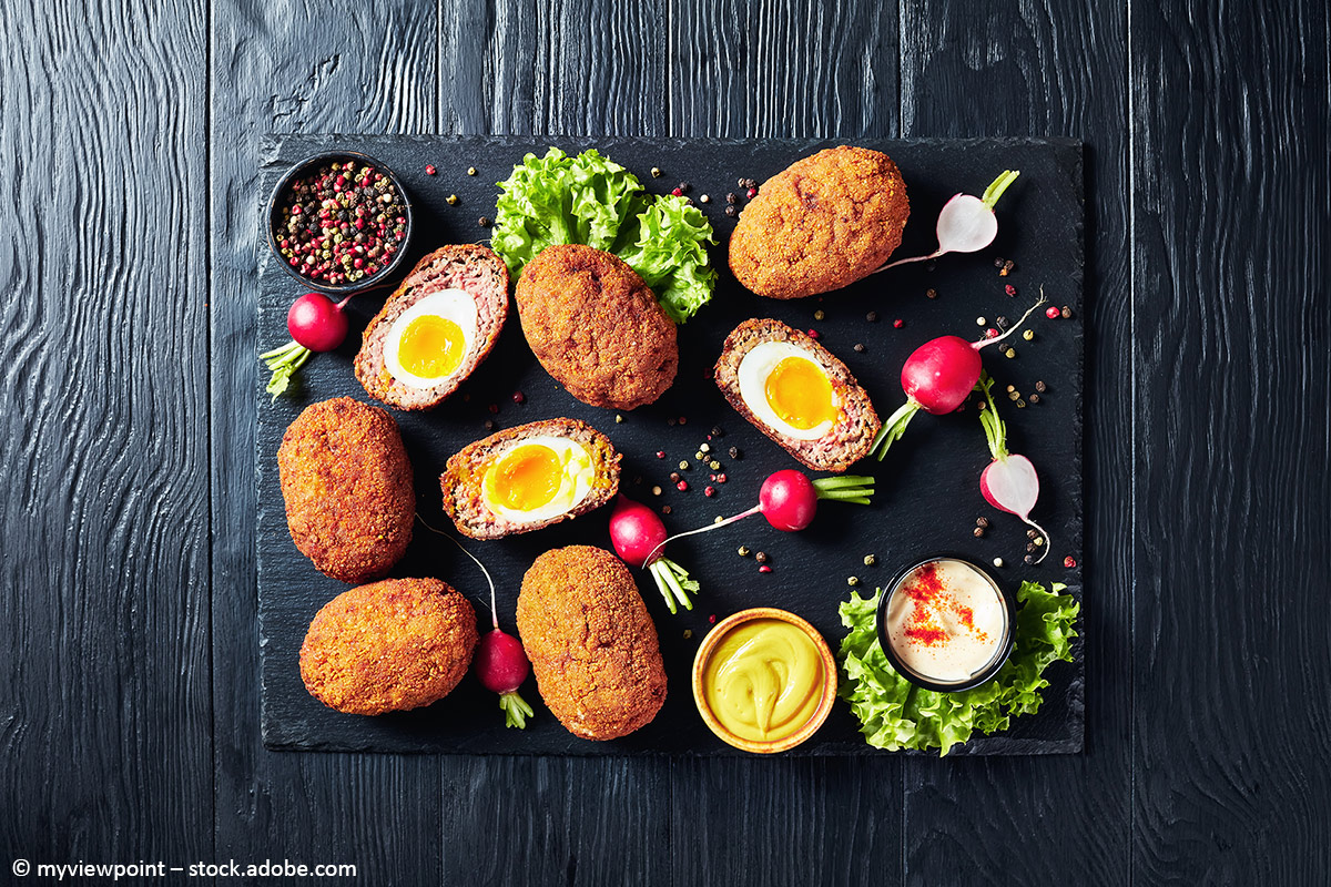 Scotch Eggs angerichtet auf einer schwarzen Platte